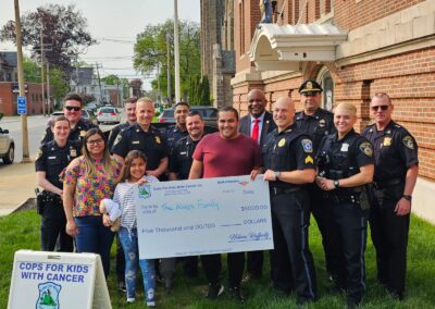 Lt. Hannagan and Sgt. Sal Mirabello, of CFKWC made a donation to the Alves Family at the Framingham Police Department. Taciele Alves is an 8 year old girl battling a brain tumor.