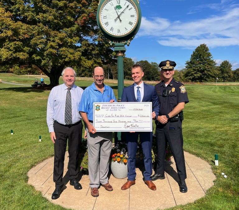 Cops for Kids with Cancer accepts a check for $3,600 from Fitchburg Police Department