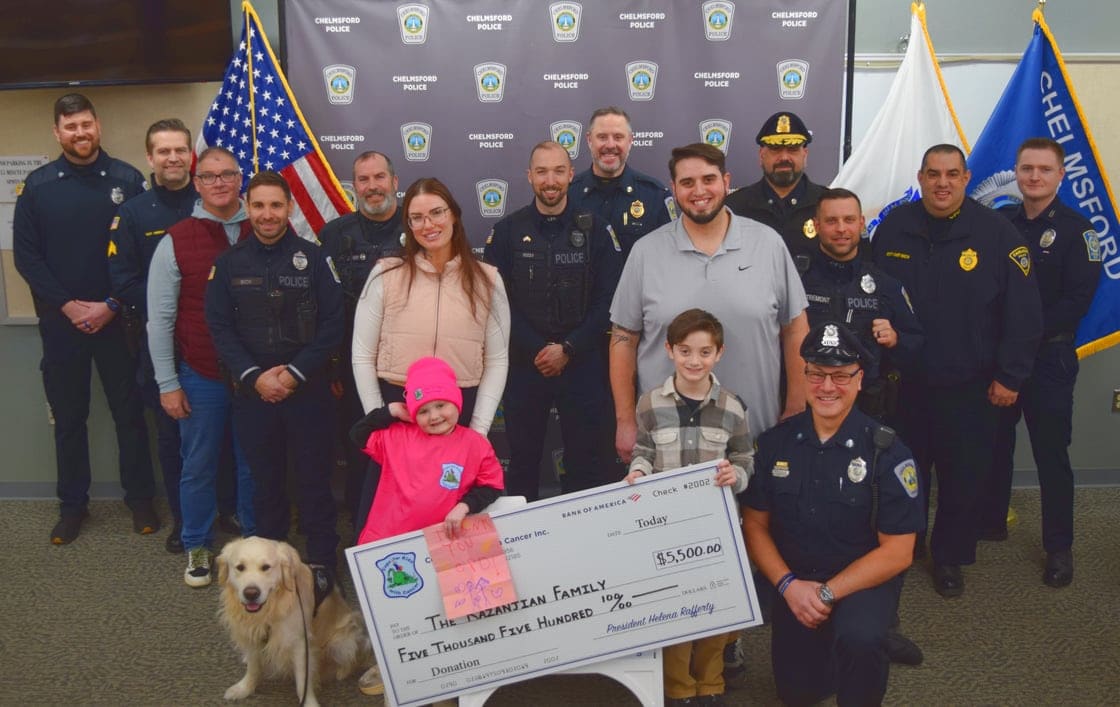 Representatives of Chelmsford Police and Cops for Kids with Cancer stand with the Kazanjian family as they present the family with $5,500 to support their ongoing battle with cancer. From left are School Resource Officer David Linstad, Sgt. Kenney Meehan, School Resource Officer Daniel Sullivan, Officer Matthew Sech, Officer Christopher Zaher, Brittany Noonan, Olivia, Officer Brandon Reedy, Lt. Daniel Goguen, Josh Kazanjian, Owen Kazanjian, Officer Corey D'Entremont, and Cops for Kids with Cancer Board Members Deputy Chief Gary Hannagan, Special Traffic Officer Sal Mirabella Jr., Carlisle Police Deputy Chief Andrew Booth, and Nashua Police Officer Ryan Linehan.