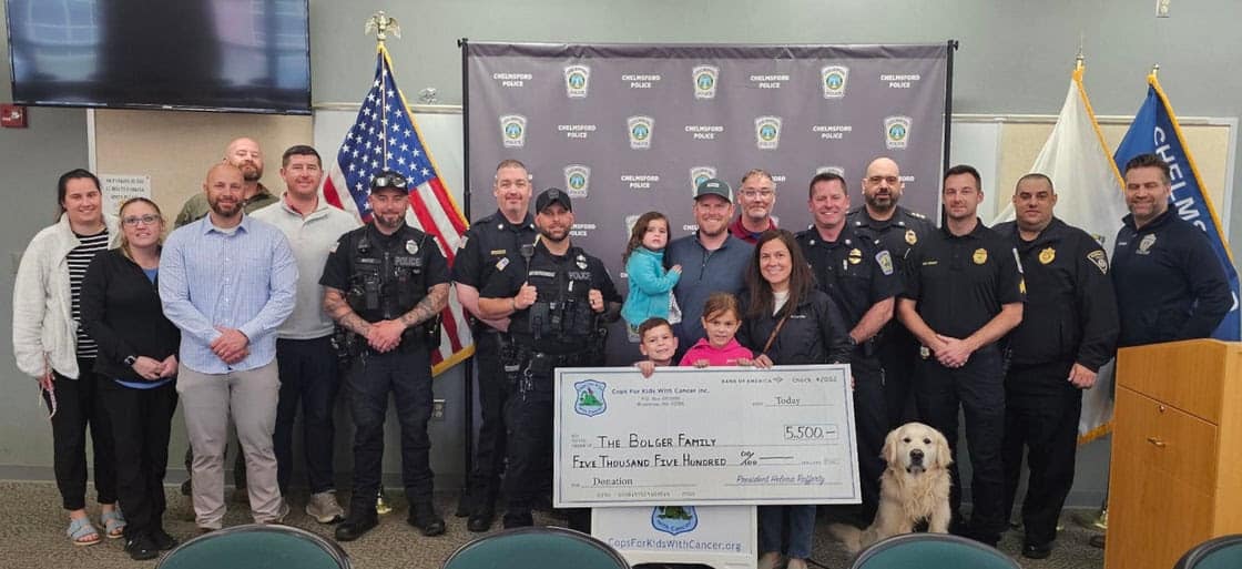 Representatives of Cops for Kids with Cancer and Chelmsford Police stand together with the Bolger family, as they present the family with $5,500 to support their ongoing battle with cancer.