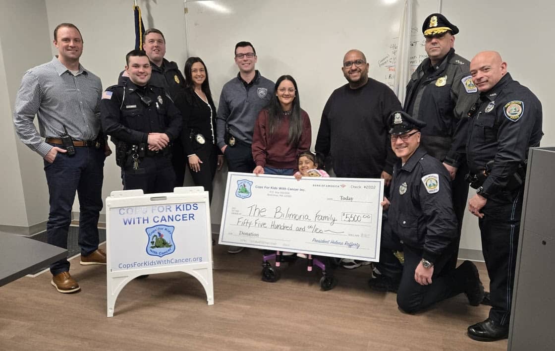 Representatives of Cops for Kids with Cancer and Burlington Police stand Zoya Bilimoria and her parents at the Burlington Police Station, just after Cops for Kids with Cancer presented the family with a $5,500 check to support Zoya's ongoing battle with a rage and aggressive form of brain cancer.